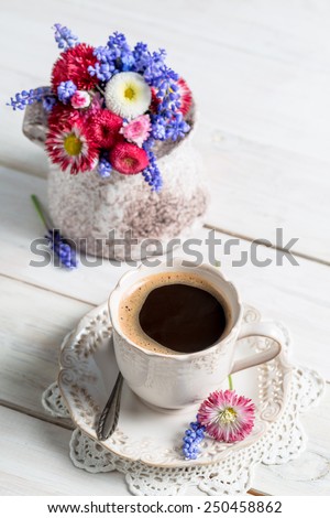 Spring flowers and coffee on old table
