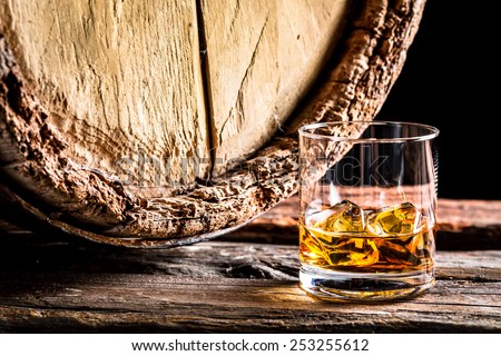 Whiskey glass and old oak barrel