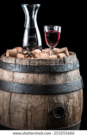 Red wine glass and carafe on old wooden barrel