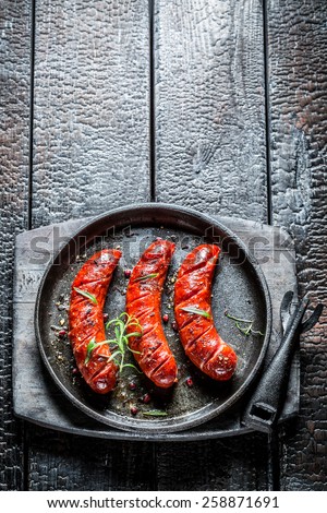 Grilled sausage with fresh herbs on hot barbecue dish