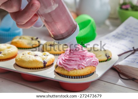 Decorating sweet cupcakes with sweet cream