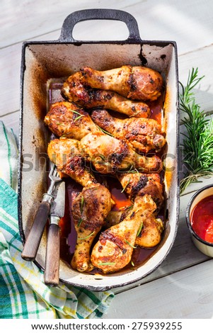 Hot chicken legs with barbecue sauce in rustic kitchen