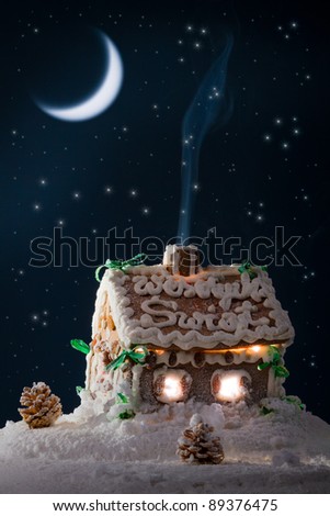 Blue smoke poured out of the gingerbread home at night in winter