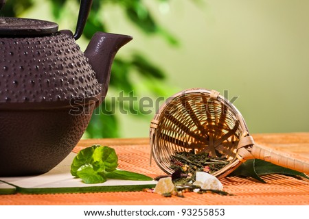 Closeup tea strainer with teapot and fresh mint leaves