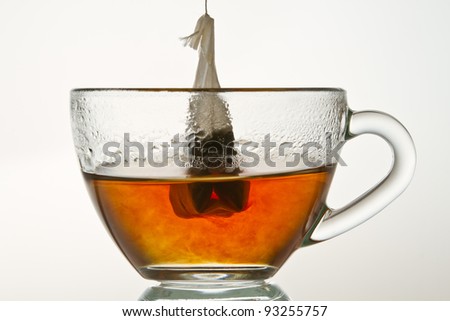 Brewing up hot tea with teabag isolated on white background