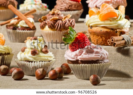 Various muffins with cream, fruits and nuts