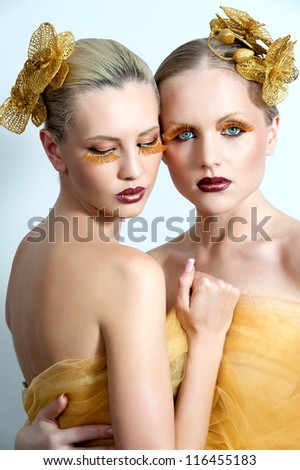 women with gold make up and gold orchid in hair