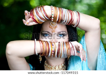 Beautiful young indian woman in traditional clothing with bridal makeup and jewelry. Bride traditionally dressed  in India. Girl bollywood dancer in Sari.
