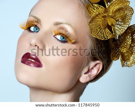woman with gold make up and gold orchid in hair