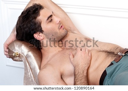 handsome young male model posing on sofa