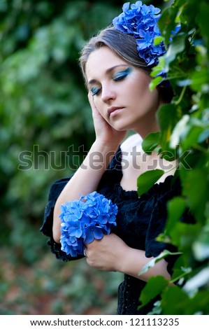 beautiful woman with stylish makeup and blue flower of  hydrangeas in your hair
