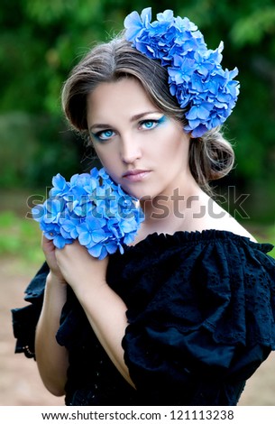 beautiful woman with stylish makeup and blue flower of  hydrangeas in your hair