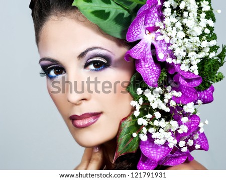 beautiful young brunette woman with an orchid in her hair