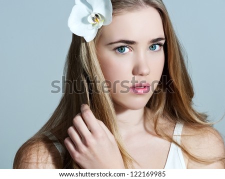 Young woman with flower in her hair - Beautiful portrait of a sexy woman with white orchid