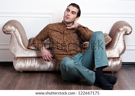 handsome young male model posing on sofa