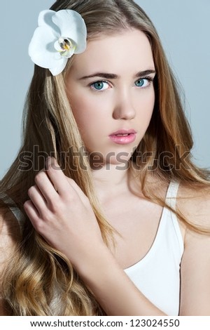 Young woman with flower in her hair - Beautiful portrait of a sexy woman with white orchid
