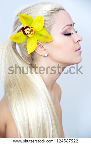 woman with bright pink orchid in her hair