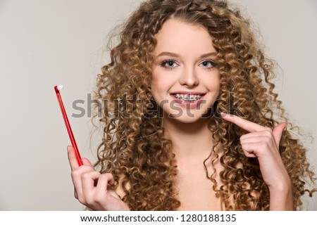 Healthy, beautiful smile, cute teen  with dental braces smiling . Portrait of a girl with orthodontic appliance. Girl brushing her teeth with toothpaste.
