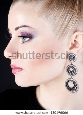 Closeup beauty portrait of attractive model face with bright visage. Violet eye makeup and pink lips make-up. Evening style.