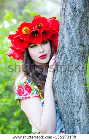 Beautiful woman with red flower wreath. Russian style
