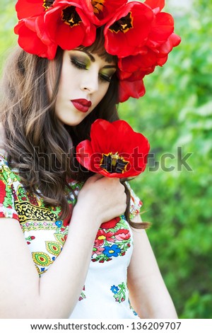 Beautiful woman with red flower wreath. Russian style