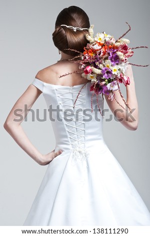 The bride with a wedding bouquet is turned by back. Hairstyle.
