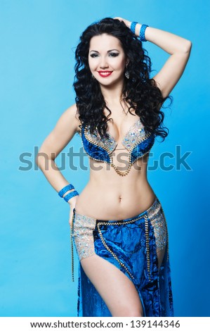 beautiful slim woman belly dancer sexy arabian turkish oriental professional artist in carnival shining costume with long healthy glossy hair. exotic star of bellydance
