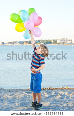 child with a bunch of balloons in their hands