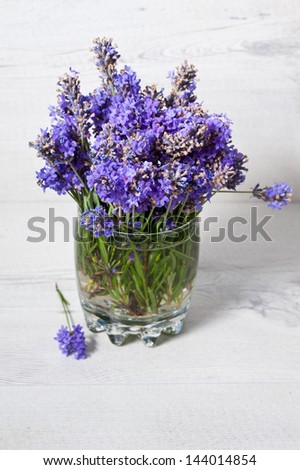 Bouquet of picked lavender flowers in vase on wooden table