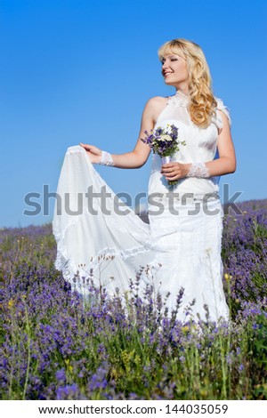 Young and beautiful bride in love, wedding day in summer. Enjoy a moment of happiness and love in a lavender field.