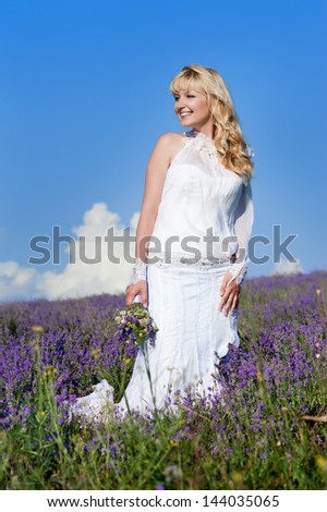 Young and beautiful bride in love, wedding day in summer. Enjoy a moment of happiness and love in a lavender field.
