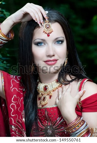 Beautiful young indian woman in traditional clothing with bridal makeup and jewelry. gorgeous brunette bride traditionally dressed Outdoors in India.
