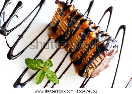 Piece of honey cake with icing of chocolate and caramel