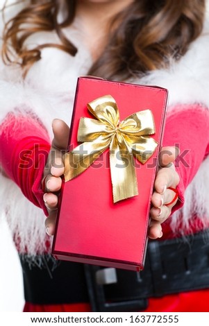 Christmas gift in hands at the beautiful girl Santa Claus
