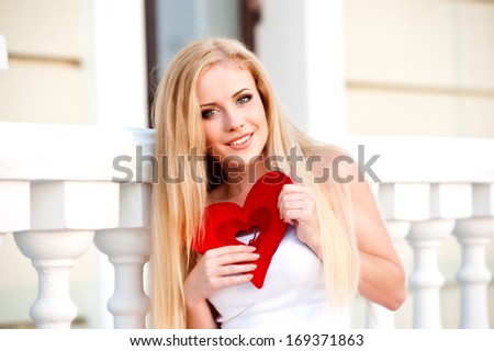 Beautiful blonde girl holding heart in hand