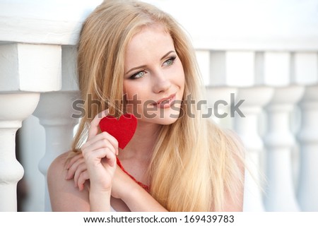 Beautiful blonde girl holding heart in hand
