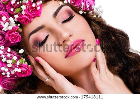 Beautiful young woman with  pink manicure, pink lips and pink roses in her hair