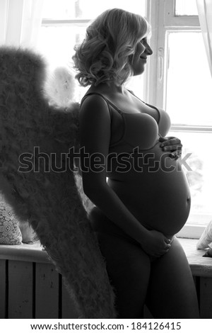 Beautiful angelic pregnant woman. Angel black white photo