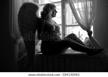 Beautiful angelic pregnant woman. Angel black white photo