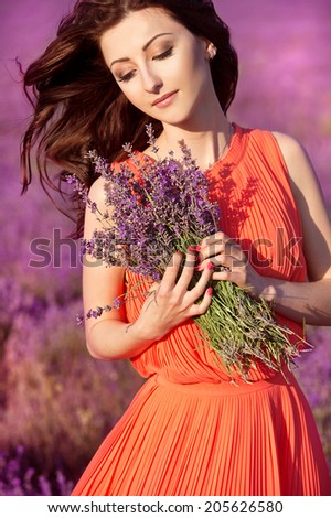 beautiful romantic woman in fairy field of lavender with bouquet