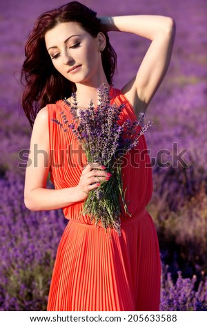 beautiful romantic woman in fairy field of lavender with bouquet