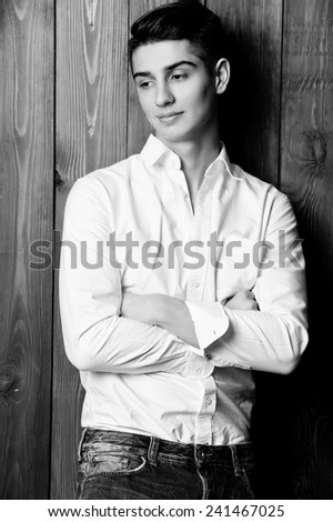 Fashion studio photo of brunette handsome man, black and white photo