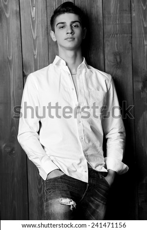 Fashion studio photo of brunette handsome man, black and white photo