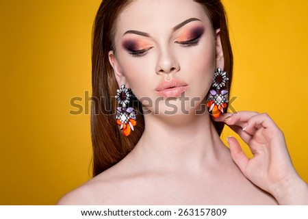 Close-up of beautiful woman face with colorful make-up and lips. Woman with bright earrings
