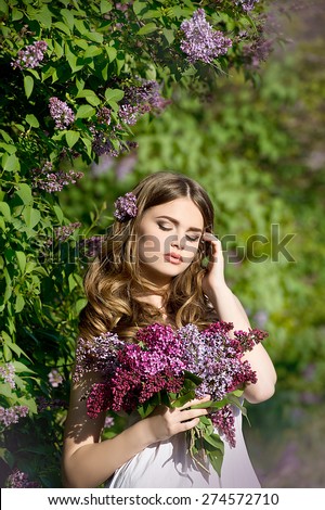 Young woman with lilac bouquet. Woman with lilac flowers in springtime.
