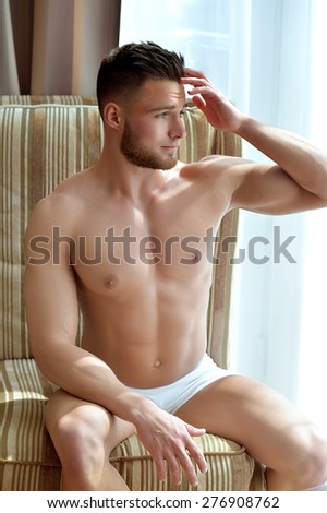 Beautiful muscular male model near window