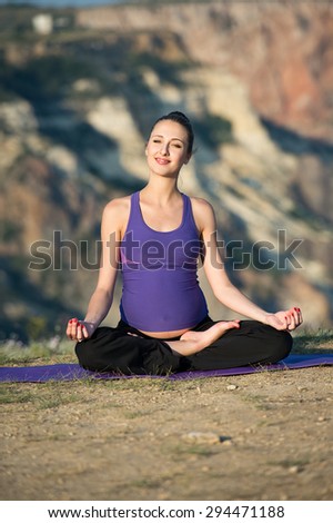Pregnant woman practicing yoga outdoor