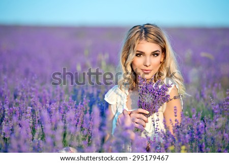 Beautiful girl on the lavender field.Beautiful blonde woman in the lavender field on sunset. Soft focus