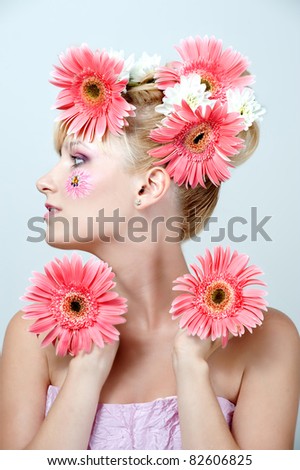 Happy young woman with  pink flowers on her  hair. Spring hairstyle.