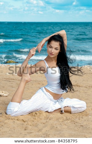attractive brunette woman in yoga poseattractive brunette woman in yoga pose and sea